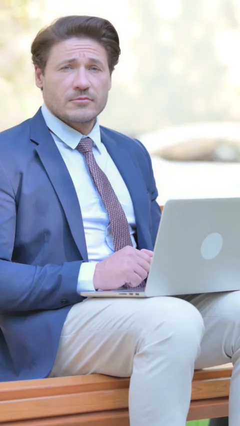 Businessman Looking at Camera while Working on Laptop Outdoor, vertical 스톡 동영상 321119476