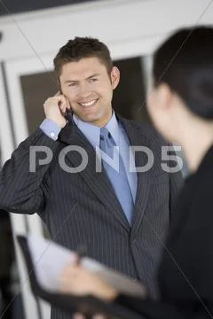 Businessman Looking At Colleague While On Call Stock Photos