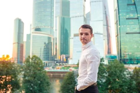 Businessman looking on copy space while standing against glass skyscraper Stock Photos