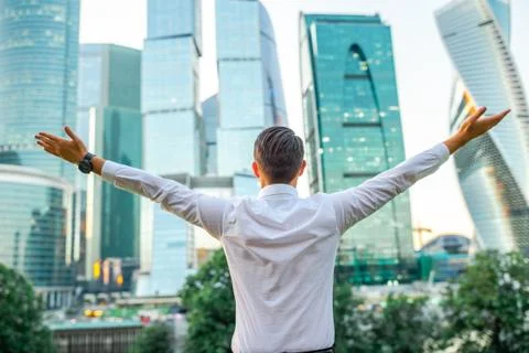 Businessman looking on copy space while standing against glass skyscraper Stock Photos