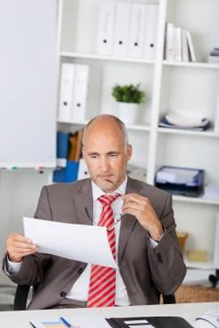Businessman looking at document at desk 写真素材