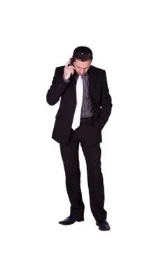 Businessman looking down while talking on the phone Stock Photos