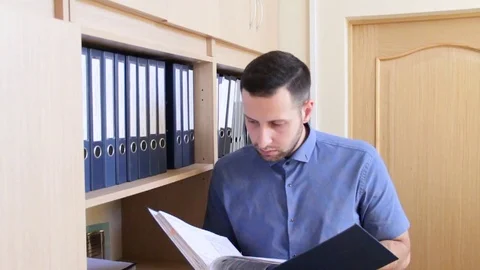 Businessman looking for a folder with documents from the archive of his office Stock Footage 84492851