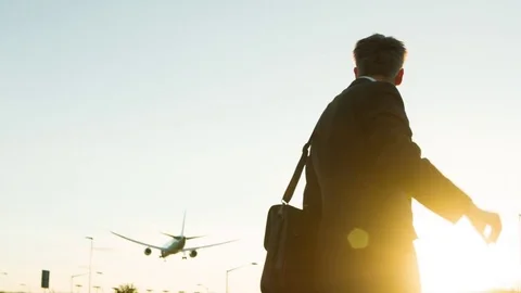 Businessman looking at his watch as a passenger plane flies overhead Video stock 77488053