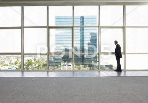 Businessman Looking Out Of Office Window Stock-Fotos
