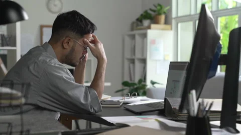 Businessman looking stressed while talking phone and using the computer Stock Footage 317752051