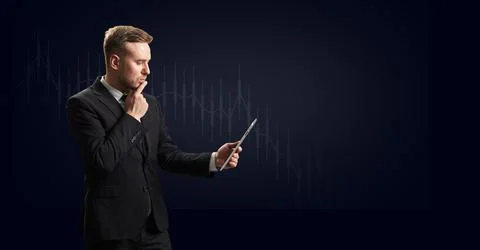 Businessman looking into a tablet computer at a falling financial loss Stock-Fotos