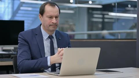 Businessman with Loss Sitting at Work, using Laptop Stock Photos