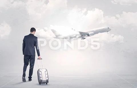 Businessman with luggage walking to airplane Stock Photos