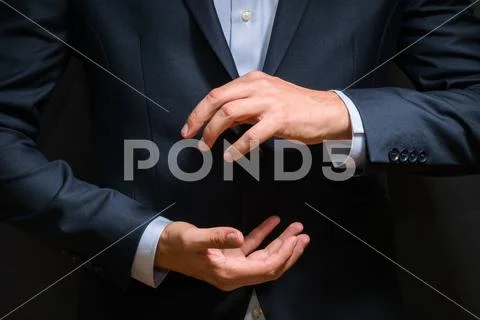 Businessman in luxury blue suit introduce new product on dark background Stock Photos
