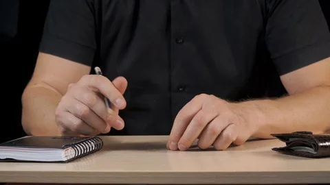 Businessman makes notes in a notebook. Shooting in the studio on a black back Stock Footage 77559528