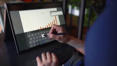 Businessman makes a presentation using stylus and convertible laptop with Stock Footage 125479168