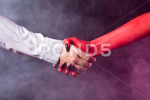 Businessman making a deal with devil Stock Photos