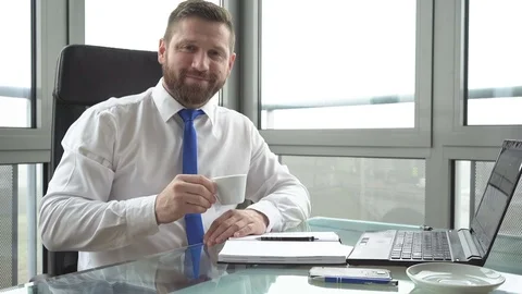 Businessman making notes, drinks coffee smiling to camera Vídeo Stock 72361731