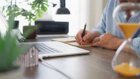 Businessman making notes while working at office desk with laptop and minia.. Stock Footage 341624782