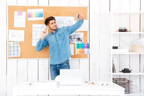 Businessman making selfie while standing in front of office board Stock Photos