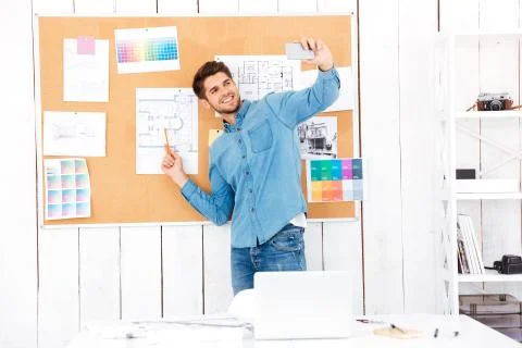Businessman making selfie while standing in front of task board Stock Photos