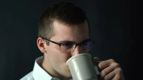 Businessman man drinks coffee while sitting in his office Stock Footage 141713447