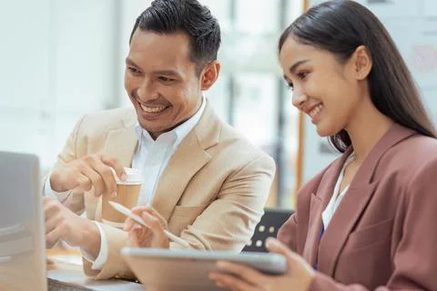 Businessman manager explaining and coaching Asian colleague financial project on Foto stock