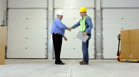Businessman meets with employee in shipping warehouse Stock Footage
