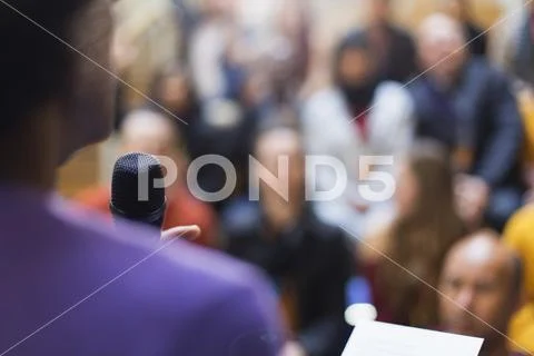 Businessman with microphone speaking to conference audience Stock Photos