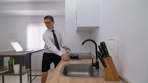 Businessman multitasking in kitchen during a virtual meeting, remote work Stock-Footage 278063452