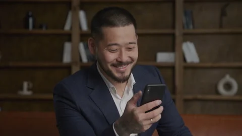 Businessman nodding head with a smile using smartphone Stock Footage 233259307