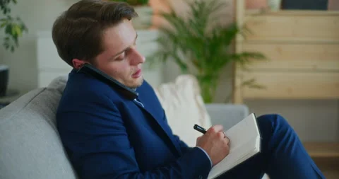 Businessman Notes While on Phone Stock Footage 276335761