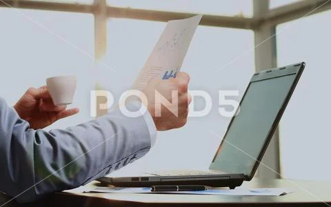 Businessman in the office deals with matters in the morning with a cup of coffee Stock Photos