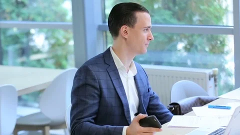Businessman in the office with a smartphon Stock Footage 70584599