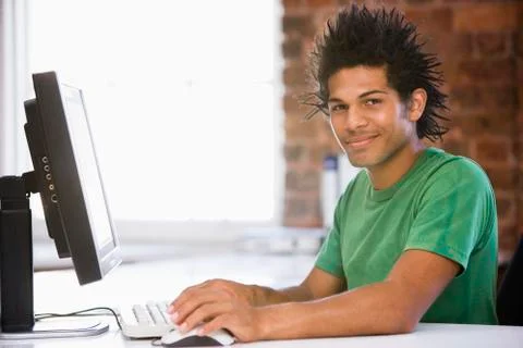 Businessman in office using computer and smiling 스톡 사진