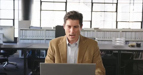Businessman in office using laptop, concentrating on video conference call Stock Footage 346285403