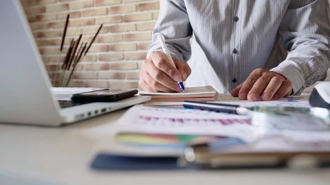 The businessman in the office writes notes to the notebook Stock Footage 92200912