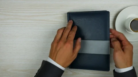 Businessman opens a diary on an empty page. Video stock 95551919