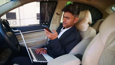 Businessman operate notebook while chatting inside car Stock Footage 310717324