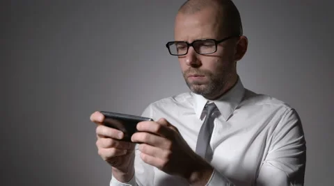 A businessman or a middle-aged manager in glasses holding a smartphone in the Stock Footage 68084589