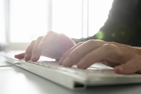 Businessman or programmer using white computer keyboard Stock-Fotos