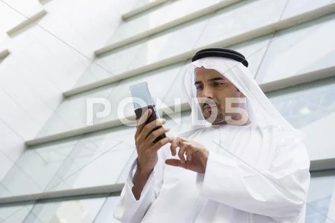 Businessman outdoors by building using PDA Stock Photos