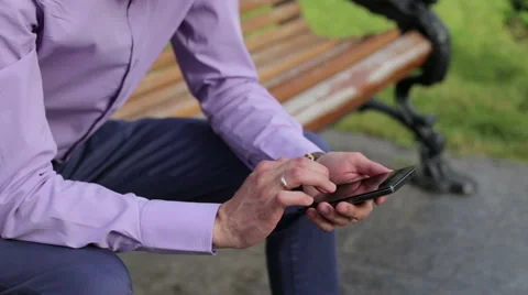 Businessman On Park Bench With Coffee Using Mobile Phone Stock-Footage 64821081