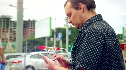 Businessman On Park Bench Using Mobile Phone in center of the city at shopping Stock Footage 54065714
