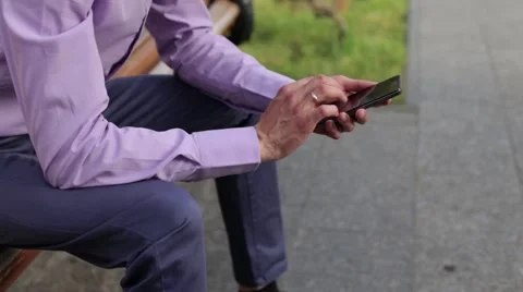 Businessman On Park Bench Using Mobile Phone Stock Footage