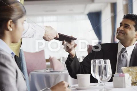 Businessman Paying The Check At Restaurant