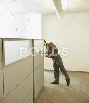 Businessman peeking around cubicle wall Stock Photos