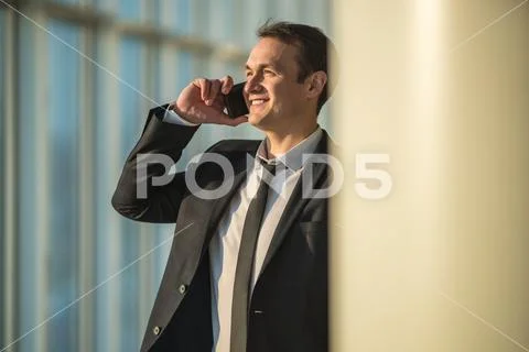 The businessman phone near the column Stock Photos
