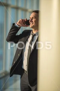 The businessman phone near the office column Stock Photos