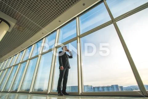 The businessman phone near the panoramic window Stock Photos