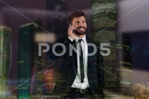 The businessman phone near the window on the background of a skyscraper Stock Photos