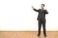 The businessman phones and gestures on the white wall background Photo