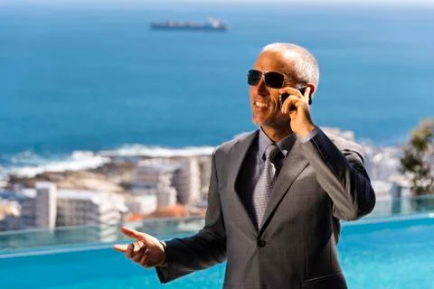 Businessman phoning by the pool Stock Photos