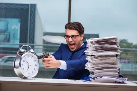 Businessman with pile stack of paper paperwork and an alarm cloc Foto stock